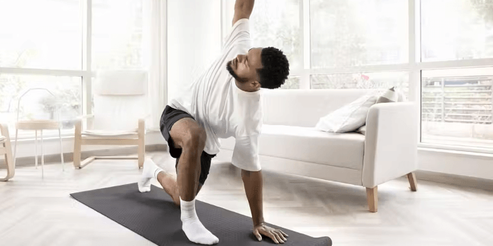 Mann macht Zuhause Yoga Übungen Nachhaltig abnehmen trotz Bürojob